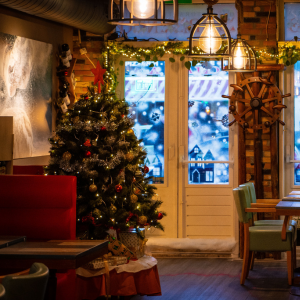 Salle du restaurant L’Absolu décorée pour les Fêtes, avec un arbre de Noël illuminé créant une ambiance chaleureuse et festive.